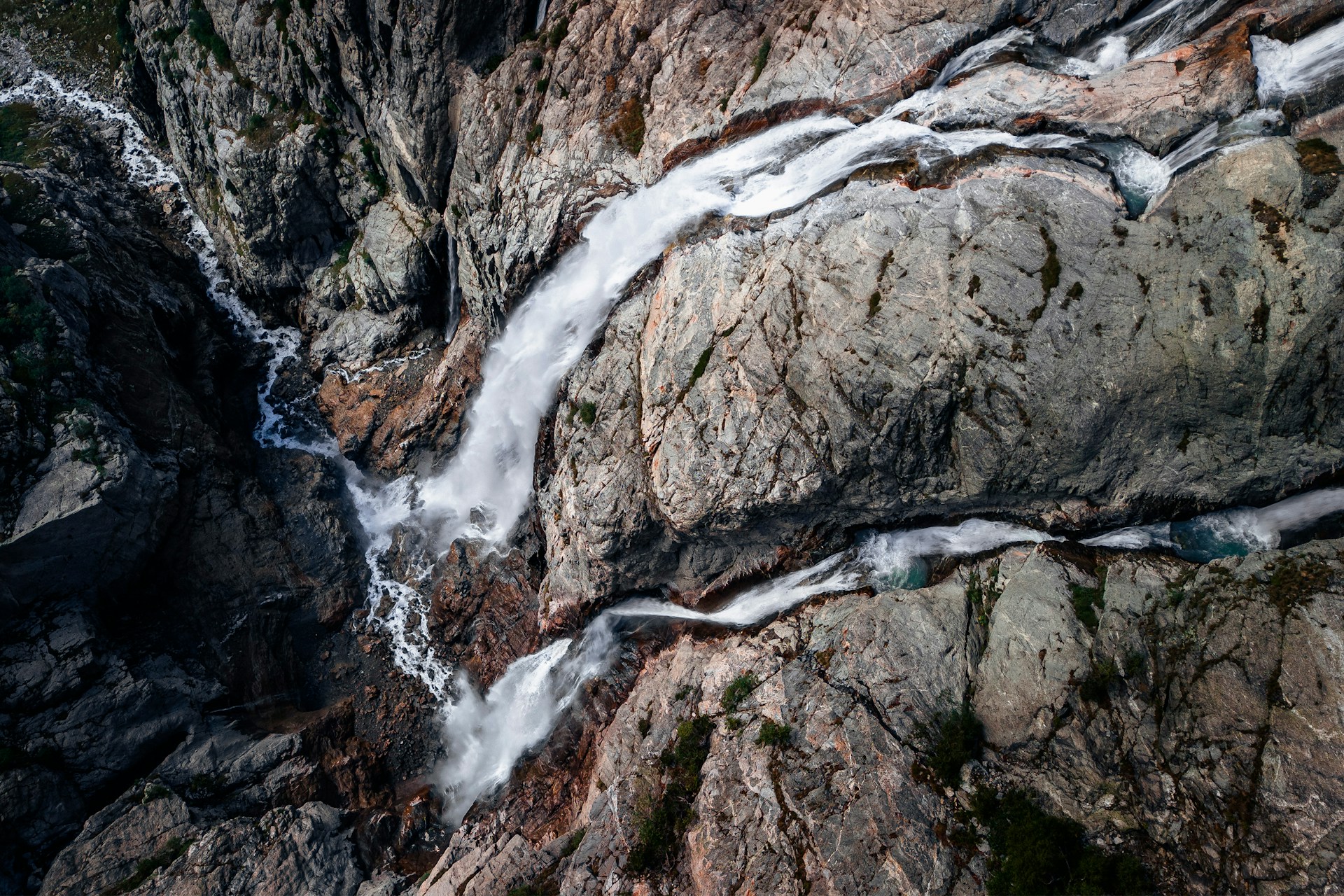 Aerial view of a powerful waterfall cascading down a rocky mountainside in the Caucasus region of Georgia