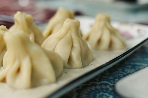Plate of traditional Georgian khinkali dumplings on a patterned tablecloth in Tbilisi