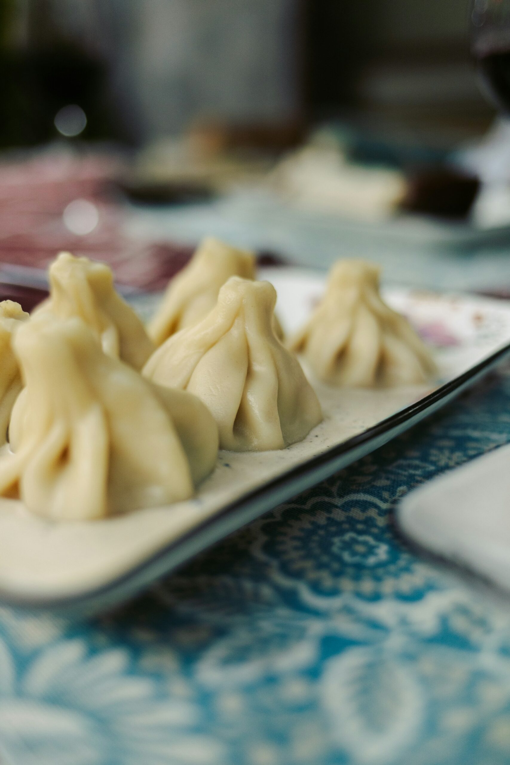 Plate of traditional Georgian khinkali dumplings on a patterned tablecloth in Tbilisi