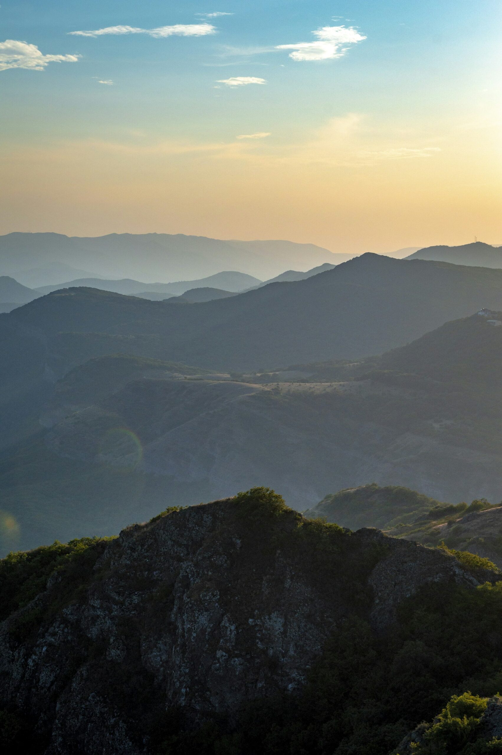 Warm sunset light bathing the Caucasus mountain range in Georgia with misty blue sky